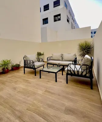 a living room with a couch and two chairs at Logement cosy avec terrasse in Casablanca