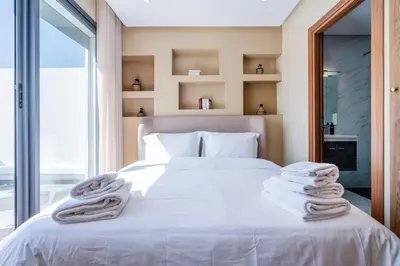 a bedroom with a white bed with towels on it at Résidence Dunkerque - Duplex in Casablanca