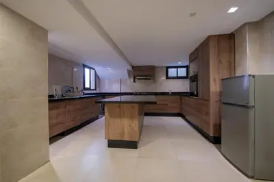 a large kitchen with a table and a refrigerator at Villa vue océan Jack Beach Bay in Tamaris