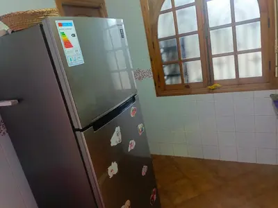 a kitchen with a stainless steel refrigerator with magnets at appartement à al tilal in Mohammedia