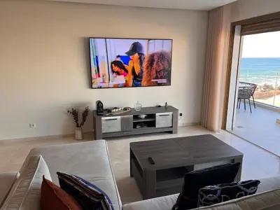 a living room with a flat screen tv on a wall at Blue Carrousel in Rabat