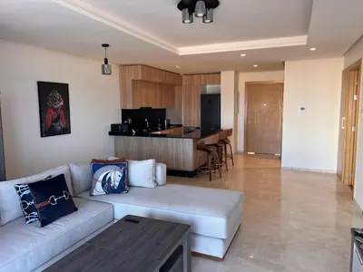 a living room with a couch and a kitchen at Blue Carrousel in Rabat