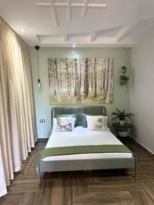 a bedroom with a bed and a painting of trees at Ferme moderne avec piscine et jardin Sejour paisible au cœur de la nature in Berrechid