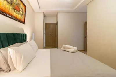 a bedroom with a large white bed with white pillows at Beautiful apartment with pool view in Aïn Harrouda
