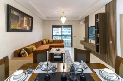 a living room with a table and a couch at Beautiful apartment with pool view in Aïn Harrouda