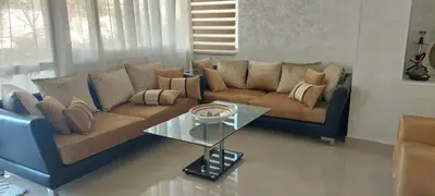 a living room with a couch and a glass table at appartement a la residence marina beach a mohammedia plage in Mohammedia