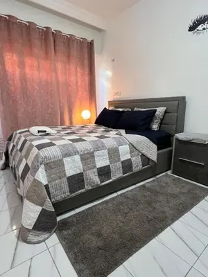 a bedroom with a bed with a checkered blanket at Super apartment Near Hassan II Mosk and Corniche in Casablanca