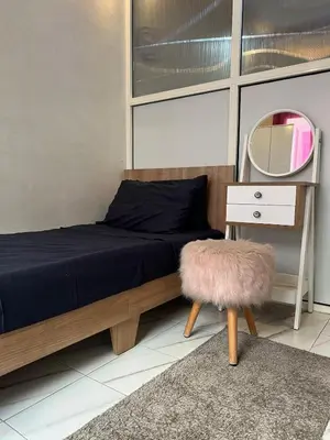 a bedroom with a bed with a mirror and a stool at Super apartment Near Hassan II Mosk and Corniche in Casablanca