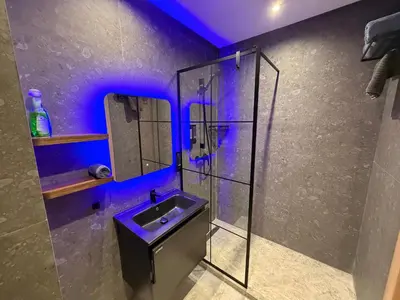 a bathroom with a sink and a shower with blue lights at Sweet Stay in Casablanca