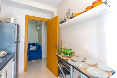 a kitchen with a table with plates on it at Spacious luxury apartment with pool in Bouznika