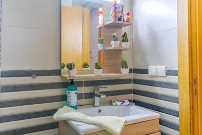 a bathroom with a sink and a mirror at Spacious luxury apartment with pool in Bouznika