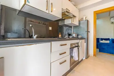 a kitchen with white cabinets and a stainless steel refrigerator at Spacious luxury apartment with pool in Bouznika