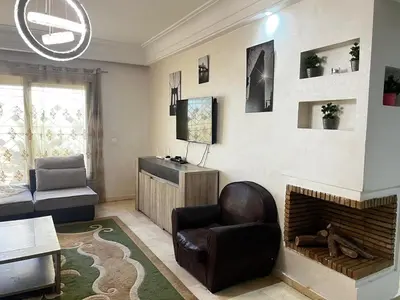 a living room with a chair and a fireplace at Maison Vacances in Casablanca