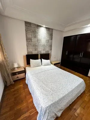 a bedroom with a large bed and a wooden floor at Maison Vacances in Casablanca