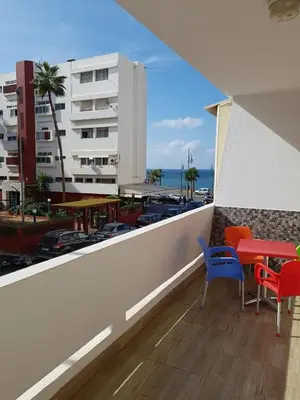 a balcony with a table and chairs and a building at Apartment at Melissa's, sea view, Res Assabah in Rabat