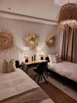 a bedroom with two beds and a desk with two lamps at downtown rabat luxury in Rabat