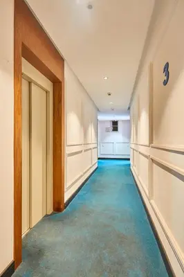 an empty hallway with blue carpeted floors and a door at Le loft du soleil B living in Casablanca