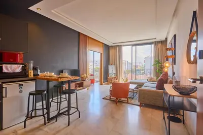 a kitchen and living room with a couch and a table at Le loft du soleil B living in Casablanca