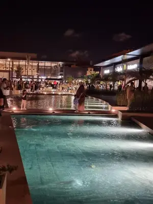 a group of people standing around a swimming pool at night at Blue paradise in Rabat
