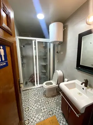 a bathroom with a shower and a toilet and a sink at appartement a louer el mansouria in Pont Blondin