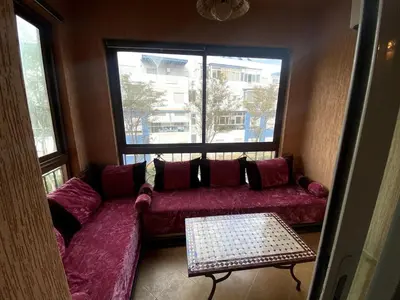 a living room with a red couch and a window at appartement a louer el mansouria in Pont Blondin