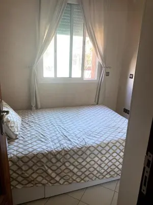 a bed in a room with a window at appartement a louer el mansouria in Pont Blondin