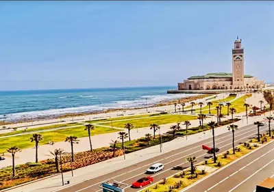 a road with a clock tower on the beach at Complexe Horizon in Casablanca