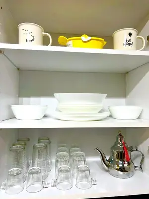 a shelf with dishes and cups and a tea kettle at Studio Neuf à Roches Noires près de Casa Voyageurs et Casa Port in Casablanca