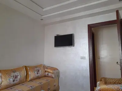 a living room with a couch and a tv on the wall at Casablanca in Casablanca