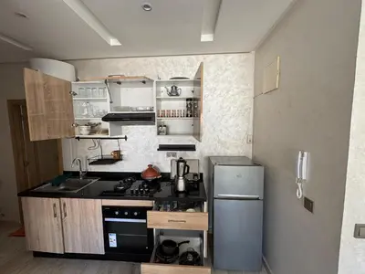 a small kitchen with a stove and a refrigerator at Cosy Studio meublé in Casablanca
