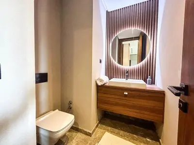 a bathroom with a toilet and a sink and a mirror at CFC Casablanca - Luxury 1-Bedroom Apartment with Anfa Park View in Casablanca