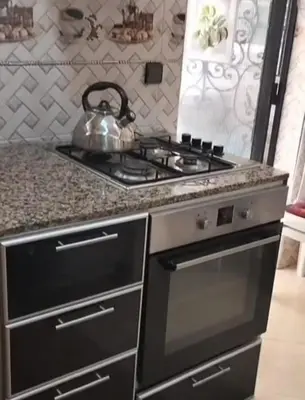 a kitchen with a stove with a tea kettle on it at Appartement Jad in Deroua