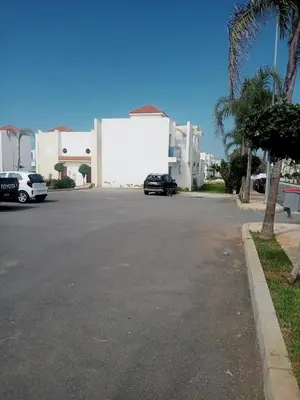 a street with a car parked in front of a building at Duplex moderne avec jardin privé 5 min de la mer in Skhirat