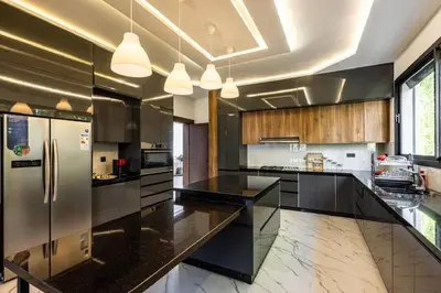 a large kitchen with black counters and stainless steel appliances at Villa Indigo in Rabat