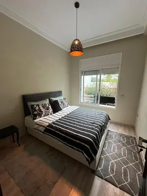 a bedroom with a large bed with a window at Appartement à 2 min Gare agdal in Rabat