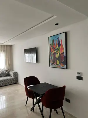 a dining room with a table and chairs and a painting at L'osmo - 1 BR - 2m from CFC in Casablanca