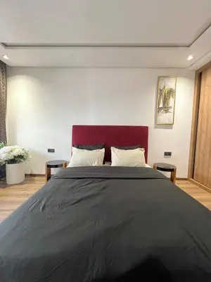 a bedroom with a large bed with a red headboard at L'osmo - 1 BR - 2m from CFC in Casablanca