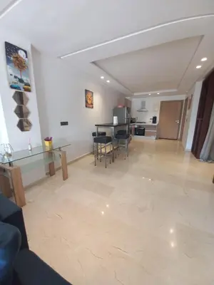 a living room with a table and chairs and a kitchen at La perle home 21 in Casablanca-Port