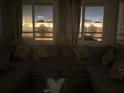 a living room with a couch and two windows at Aziz in Casablanca