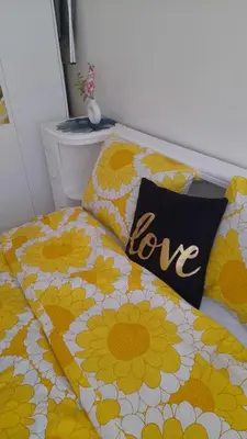 a bed with yellow and white flowers with a love pillow at Baraka house in Sidi Yahia az Zaʼer