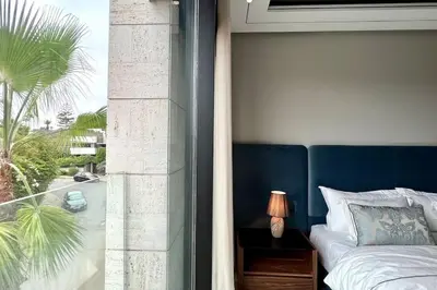 a bedroom with a bed and a window with a palm tree at Anfa The Address - By AppartAli in Casablanca