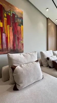 a room with white pillows and a painting on the wall at Casa The Address - By AppartAli in Casablanca
