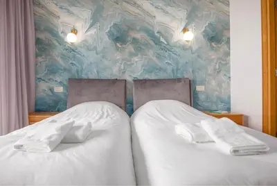 a bedroom with two beds with white sheets at La Terrazza at Marina - By AppartAli in Casablanca