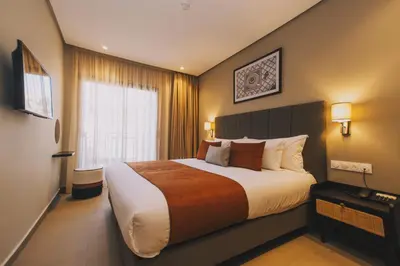 a hotel room with a large bed and a window at Dally Apart Hotel in Rabat