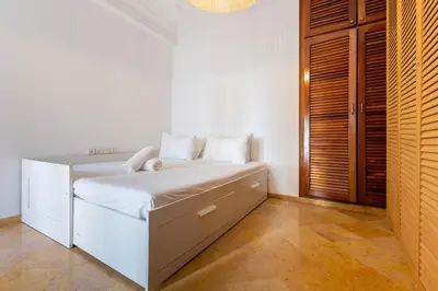 a white bedroom with a bed with white sheets at 3BR Apartment in Prestigious Hay Riad by MERAT HOME in Rabat