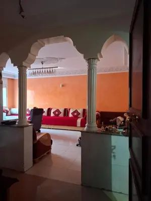 a living room with a red couch and columns at Composed of 2 bedrooms and large living room in Casablanca