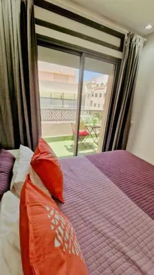 a bedroom with a bed with orange pillows and a window at Fundays Stay Casablanca in Casablanca