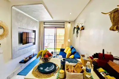 a living room with a table and a couch at Fundays Stay Casablanca in Casablanca