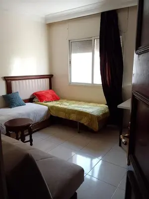 a small room with two beds and a window at Appartement Chahdia in Casablanca
