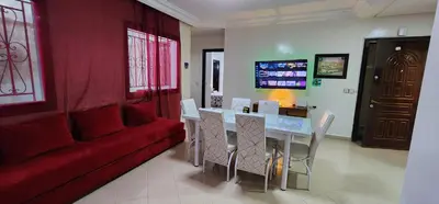 a living room with a red couch and a table and chairs at Privat Room in a Shard Apartment next to MOSQUÉE HASSAN 2 in Casablanca